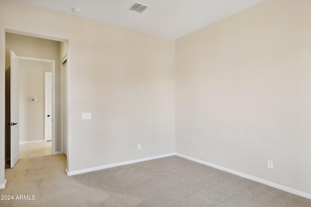 spare room featuring light colored carpet