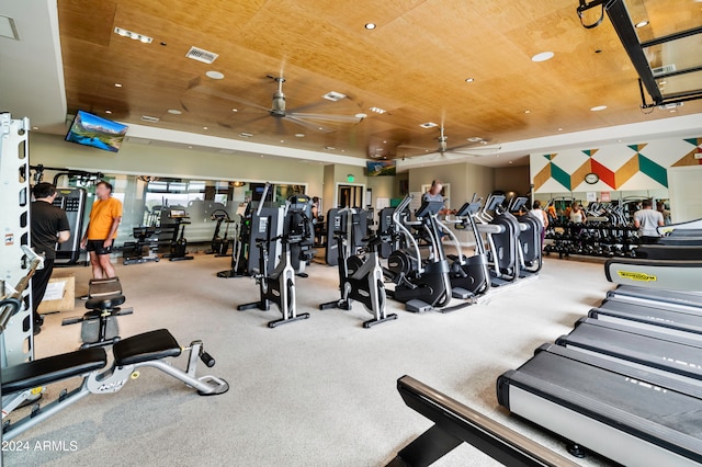 exercise room featuring carpet flooring, ceiling fan, and wood ceiling