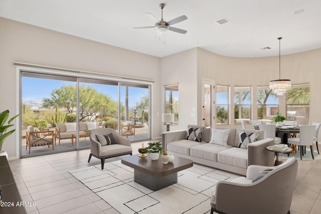 living room featuring ceiling fan with notable chandelier and light tile patterned floors