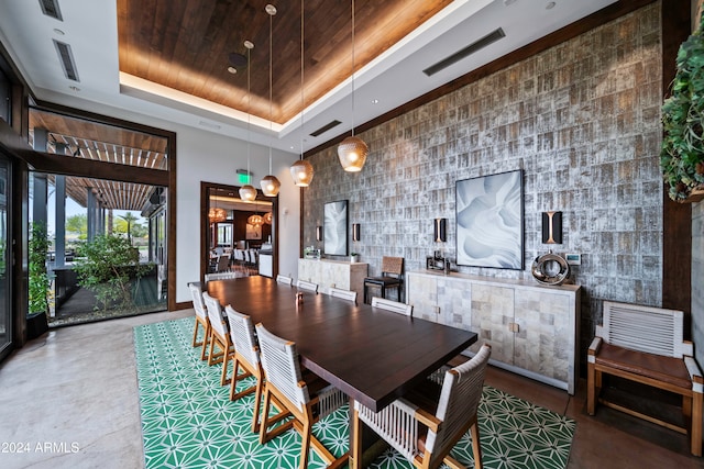 dining room featuring tile walls, wood ceiling, concrete floors, and a raised ceiling