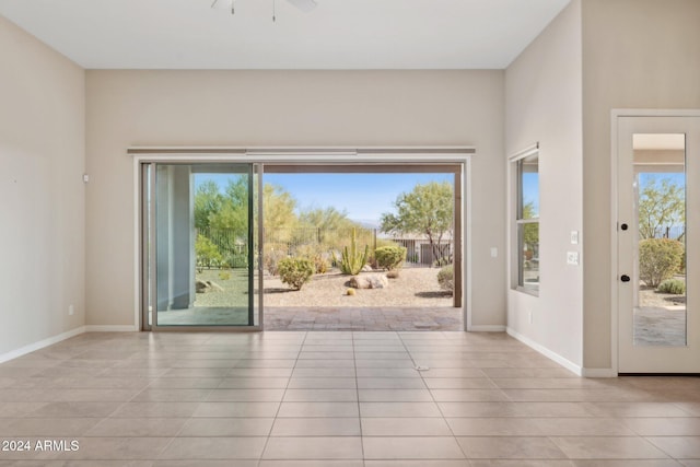 doorway to outside featuring ceiling fan, a wealth of natural light, and light tile patterned flooring