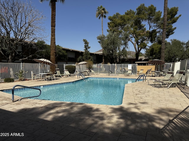 pool with a patio area and fence