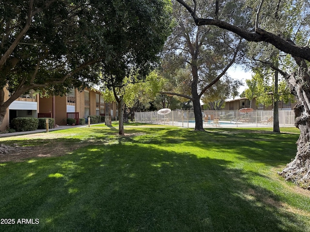 surrounding community featuring a yard, fence, and a swimming pool