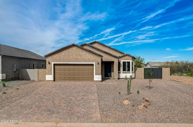 8529 W Reventon Dr, Arizona City, AZ 85123 - ranch-style house featuring stucco siding, fence, an attached garage, decorative driveway, and a gate