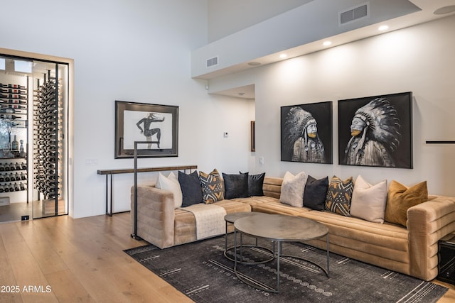 living room with a towering ceiling and hardwood / wood-style floors