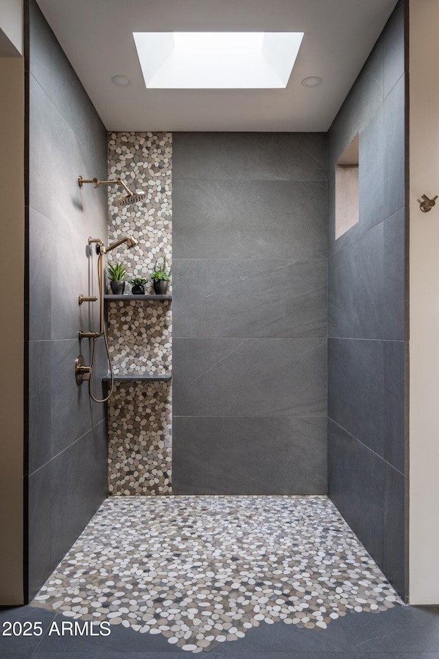 bathroom with a skylight and tiled shower