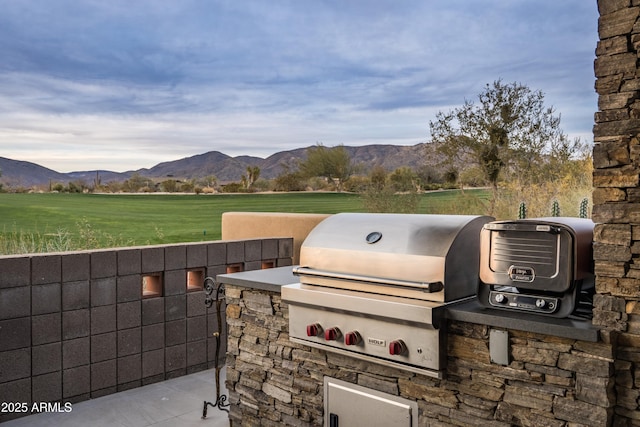 view of patio / terrace with area for grilling, a mountain view, and a grill