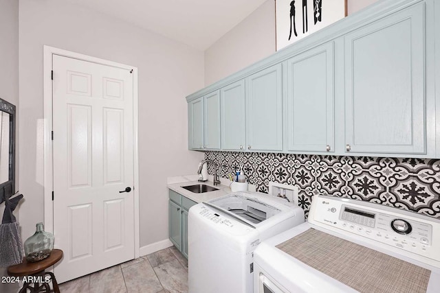 clothes washing area with washer and dryer, cabinets, light tile patterned floors, and sink