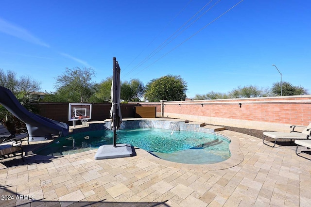 view of pool with pool water feature, a patio area, and a water slide