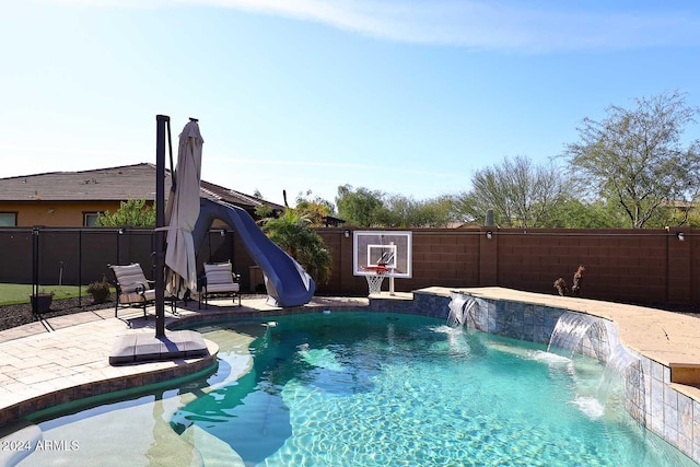 view of pool featuring pool water feature, a water slide, and a patio