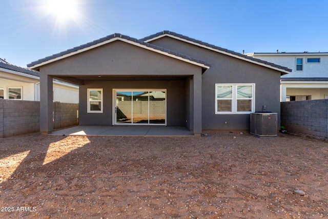 rear view of house with central AC and a patio area