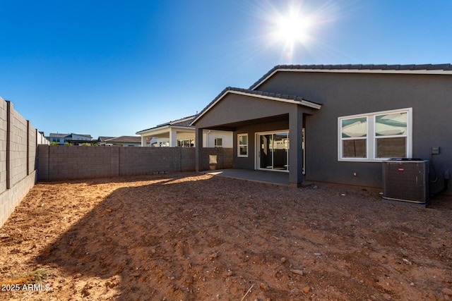 rear view of property with central AC and a patio