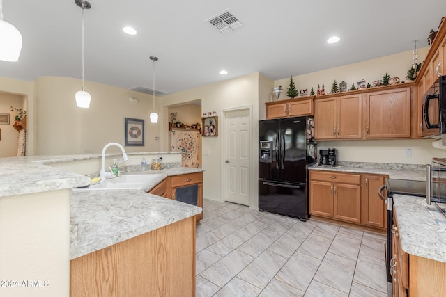 kitchen featuring visible vents, hanging light fixtures, light countertops, black appliances, and a sink