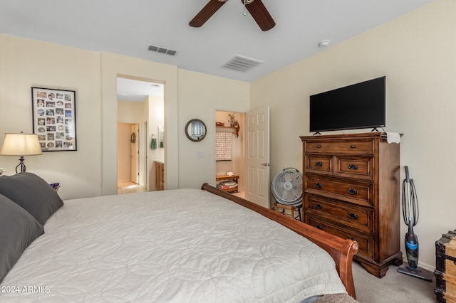 carpeted bedroom with connected bathroom, visible vents, and a ceiling fan