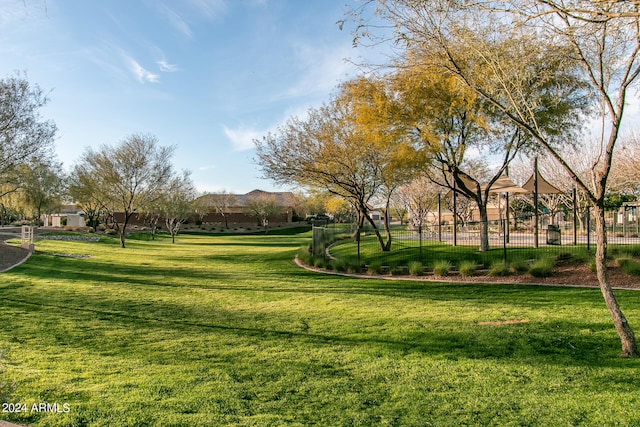 view of property's community featuring a yard and fence