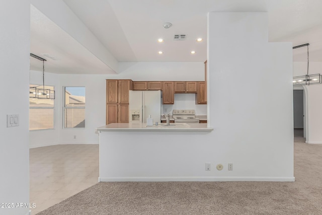 kitchen featuring decorative light fixtures, a chandelier, light colored carpet, kitchen peninsula, and white appliances