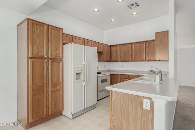 kitchen with sink, white appliances, and kitchen peninsula