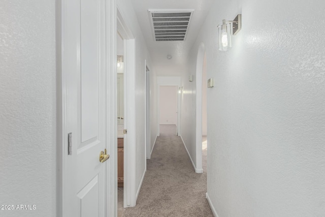 corridor featuring light colored carpet