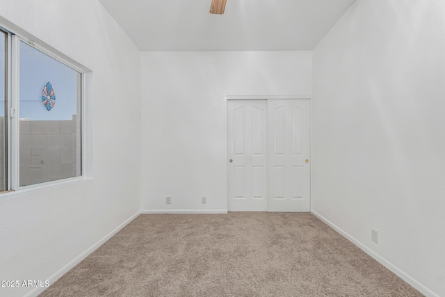 unfurnished room featuring ceiling fan and light colored carpet