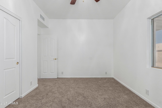 carpeted spare room featuring ceiling fan