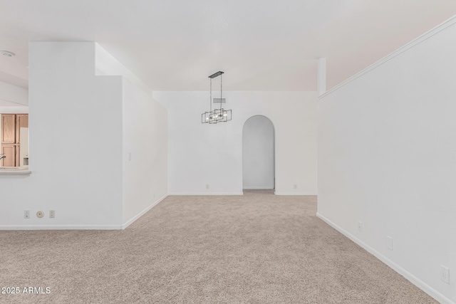 carpeted empty room with an inviting chandelier