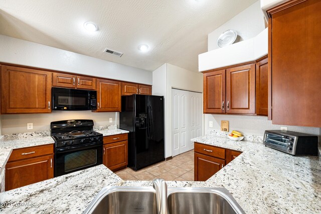 630 W Cattle Drive Trl, Flagstaff, AZ 86005 - kitchen with brown cabinetry, visible vents, black appliances, light tile patterned flooring, and a sink