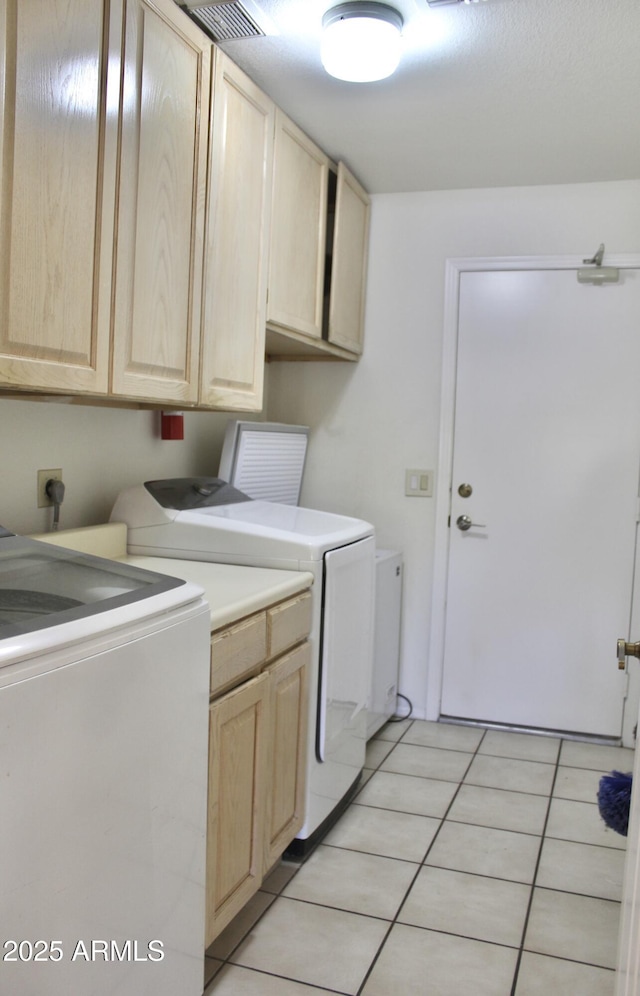 clothes washing area with cabinet space, independent washer and dryer, visible vents, and light tile patterned flooring