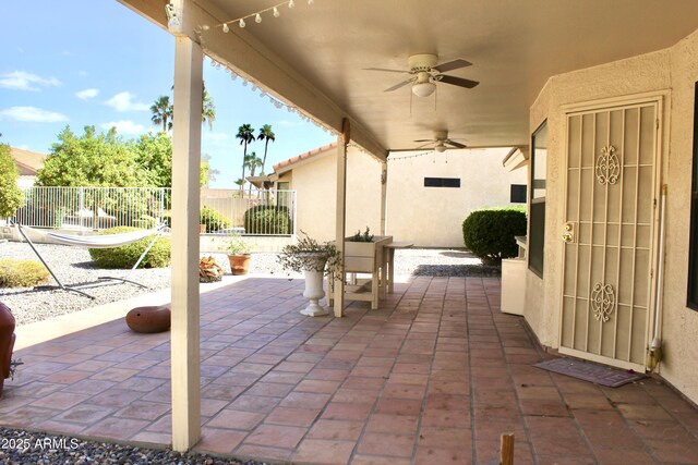 view of patio / terrace featuring ceiling fan and fence