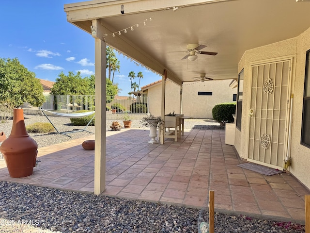 view of patio featuring fence and a ceiling fan