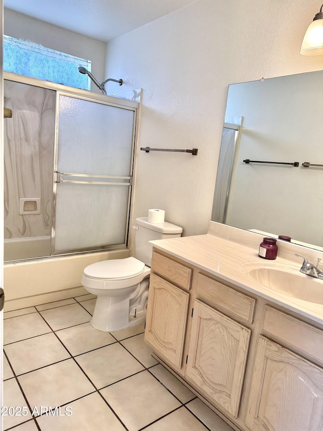 bathroom with bath / shower combo with glass door, vanity, toilet, and tile patterned floors