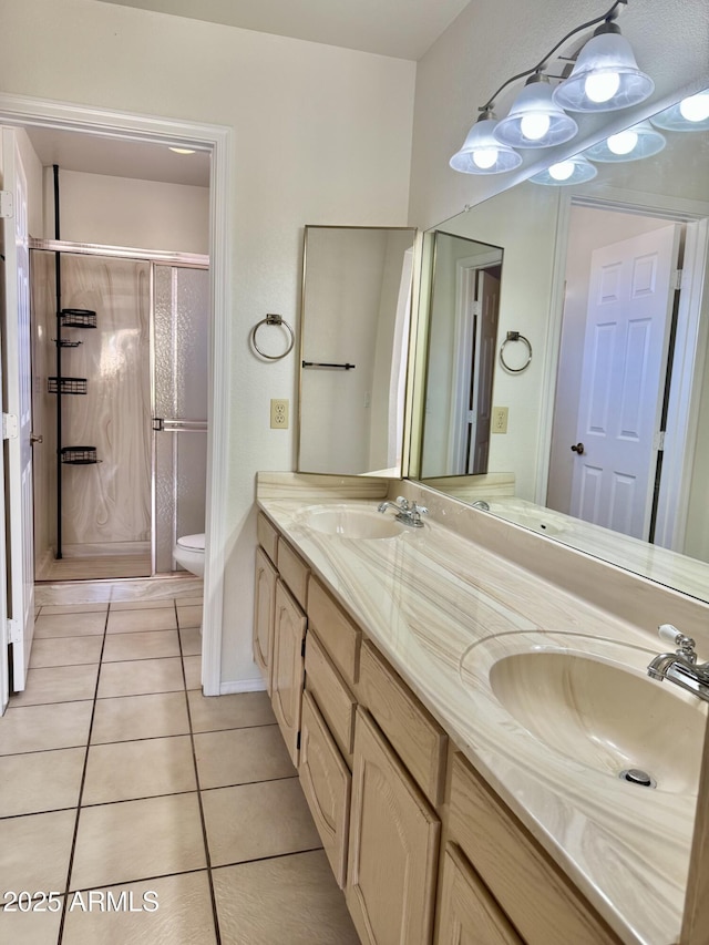 bathroom featuring a stall shower, a sink, toilet, and tile patterned floors