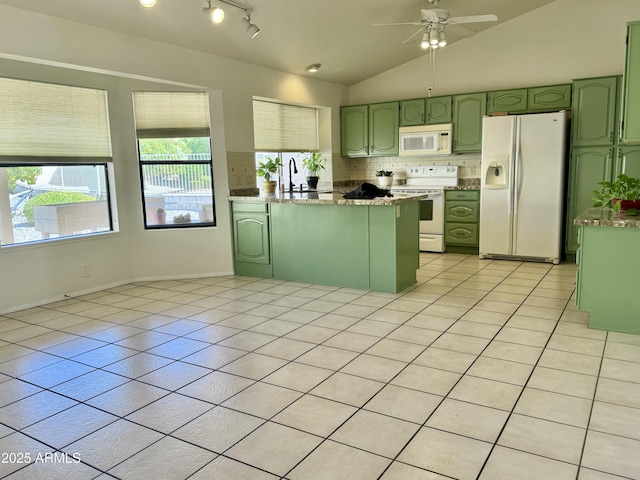 kitchen with light tile patterned floors, a peninsula, white appliances, green cabinets, and tasteful backsplash