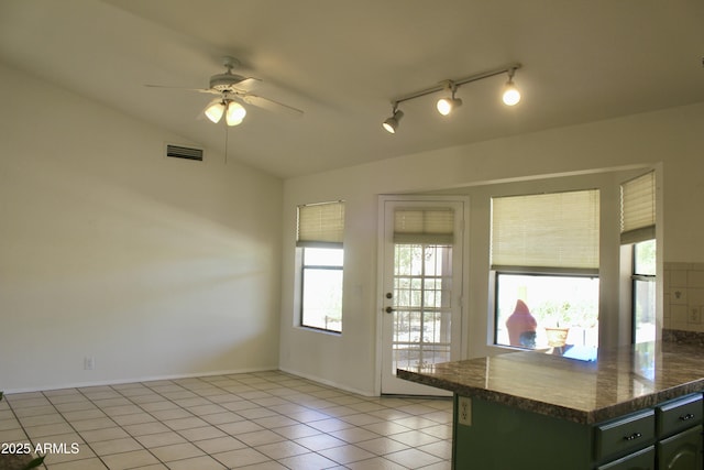 kitchen featuring dark countertops, visible vents, lofted ceiling, and light tile patterned floors