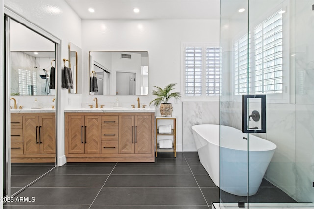 10415 E Rosemary Ln, Scottsdale, AZ 85255 - bathroom featuring a soaking tub, double vanity, tile patterned floors, a stall shower, and tile walls