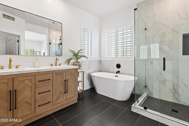 10415 E Rosemary Ln, Scottsdale, AZ 85255 - full bath featuring a stall shower, tile patterned floors, a freestanding tub, double vanity, and tile walls