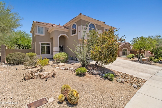 10415 E Rosemary Ln, Scottsdale, AZ 85255 - mediterranean / spanish home featuring stucco siding, a tiled roof, concrete driveway, and fence