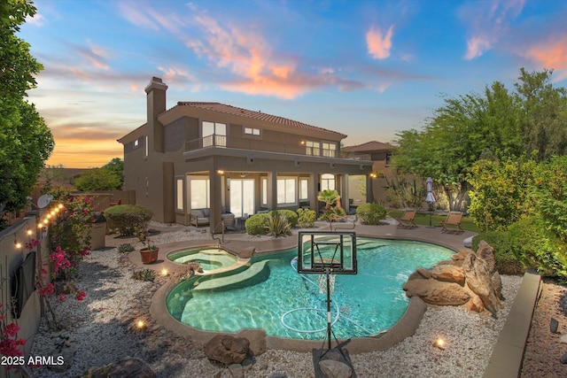 10415 E Rosemary Ln, Scottsdale, AZ 85255 - pool at dusk featuring a patio, a pool with connected hot tub, and fence