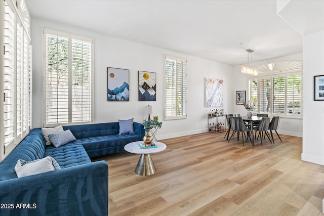 10415 E Rosemary Ln, Scottsdale, AZ 85255 - living area with wood finished floors, baseboards, a chandelier, and plenty of natural light