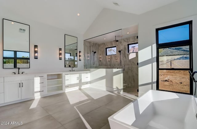 bathroom with a wealth of natural light, a marble finish shower, a soaking tub, two vanities, and a sink