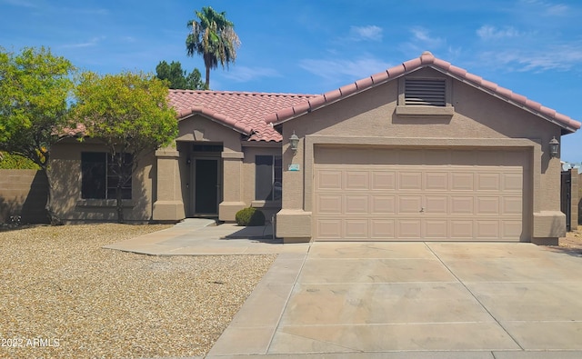 view of front of home featuring concrete driveway, a tile roof, an attached garage, and stucco siding