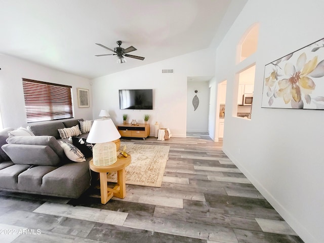 living area featuring lofted ceiling, ceiling fan, wood finished floors, visible vents, and baseboards