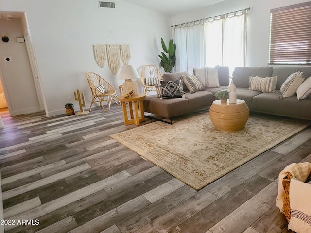 living area with visible vents, baseboards, and wood finished floors