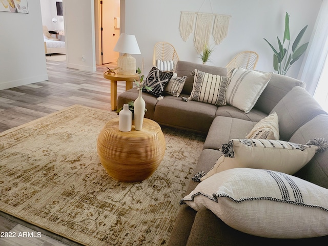 living area with baseboards and wood finished floors