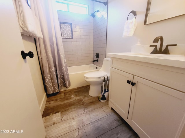 full bath with toilet, shower / bath combo, wood finished floors, and vanity