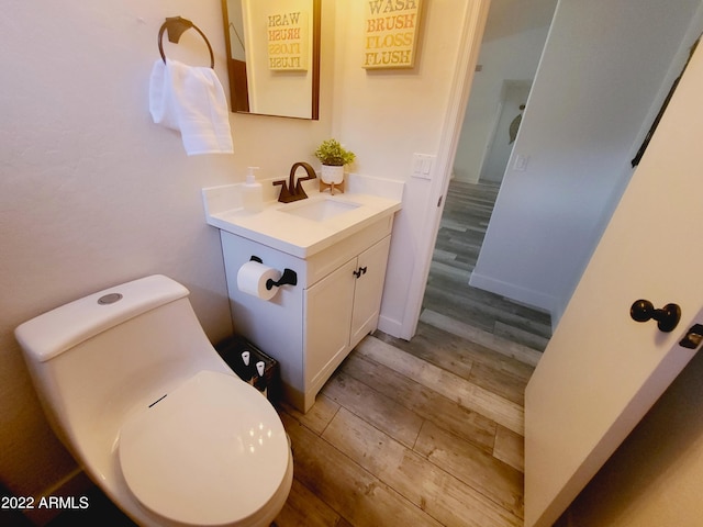 bathroom with vanity, toilet, and wood finished floors