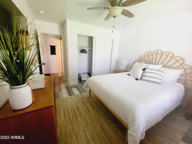 bedroom featuring a ceiling fan, a closet, and wood finished floors