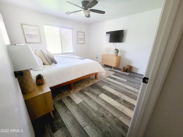 bedroom with wood finished floors, visible vents, and a ceiling fan