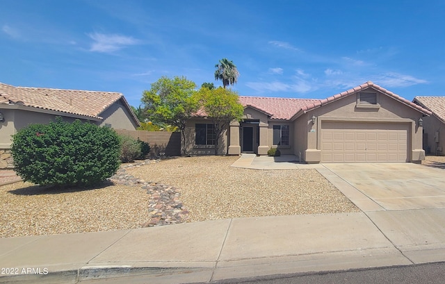 ranch-style home with a garage, stucco siding, concrete driveway, and a tiled roof