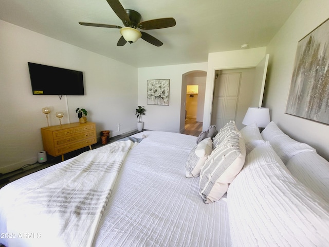 bedroom featuring arched walkways and a ceiling fan