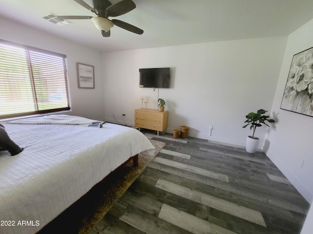 bedroom featuring visible vents, ceiling fan, baseboards, and wood finished floors